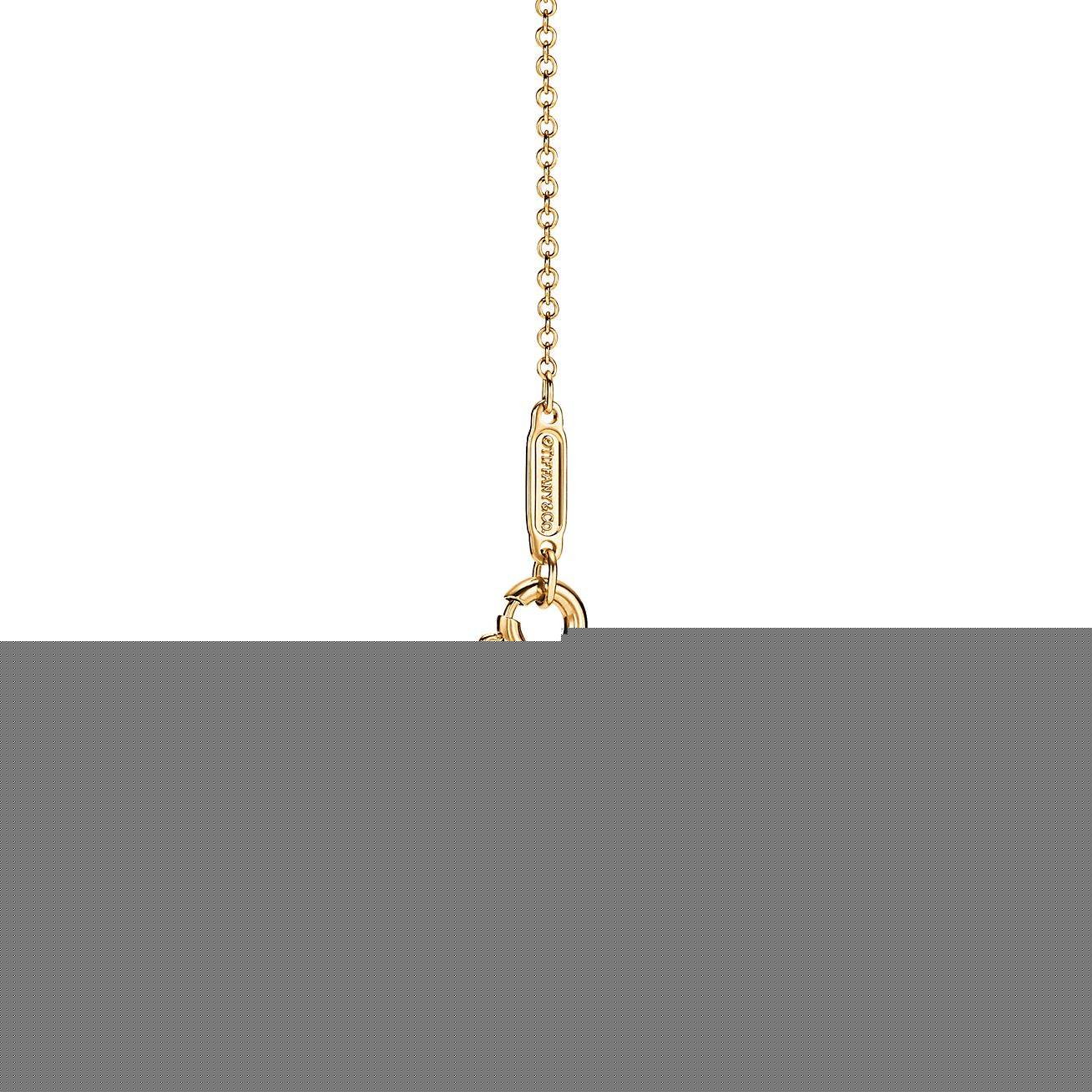 T*f*ny t diamond pendant in 18k gold with a baguette diamond